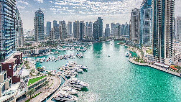 A marina with numerous boats docked, surrounded by high-rise buildings and a clear sky. - Maison Privee - Aesthetic Apt w/ Stunning Vw in Luxurious Building (Dubai)