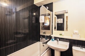 Un baño moderno con bañera, lavamanos e inodoro.