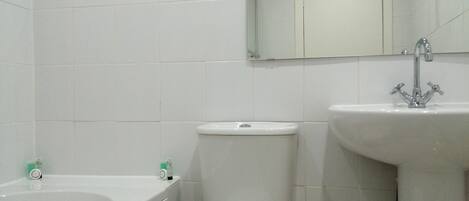 Une salle de bain avec une baignoire, des toilettes et un lavabo.