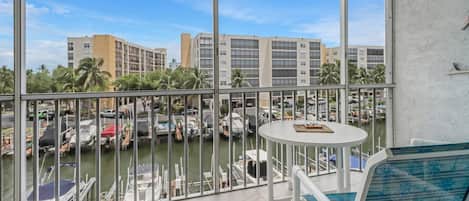 Un balcón con vista a un puerto deportivo y edificios.