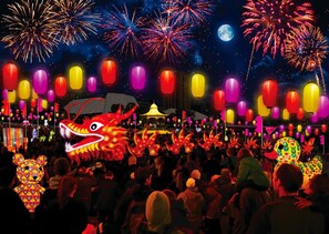 Experience the vibrant atmosphere of a lively night scene with fireworks illuminating the sky.