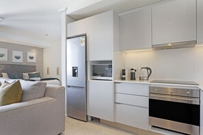 A modern kitchen with white cabinetry, a built-in microwave, and an oven.