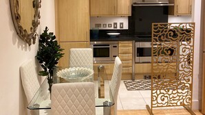 A modern kitchen with wooden cabinets, a built-in oven, and a microwave.