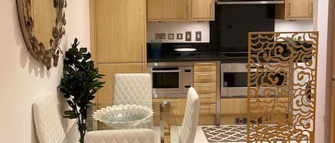 A modern kitchen with wooden cabinets, a built-in oven, and a microwave.