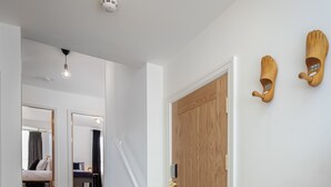 A wooden staircase leading to a bedroom with a bed, a nightstand, and a dresser. - Blueberries Apartments by Sasco (Blackpool)