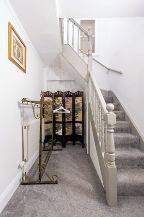A staircase with a white handrail and carpeted steps.