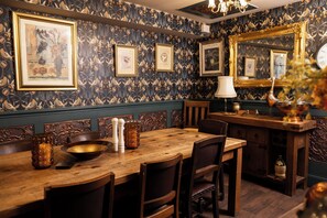 A dining area with a wooden table, chairs, and a mirror above. - The Old Clock Tower Central Skipton Luxury Apartment 60+ 5* Reviews on platforms (Skipton)
