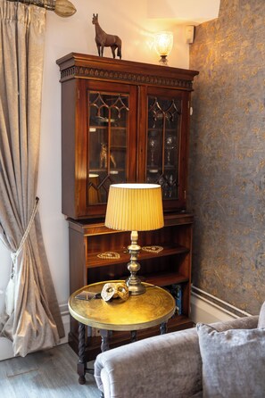 A room with a wooden cabinet, a lamp on a small table, and a curtain. - The Old Clock Tower Central Skipton Luxury Apartment 60+ 5* Reviews on platforms (Skipton)