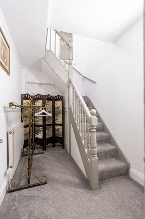 A staircase with white balusters and carpeted steps leading to an upper floor. - The Old Clock Tower Central Skipton Luxury Apartment 60+ 5* Reviews on platforms (Skipton)