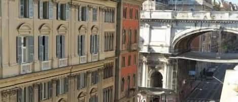 A street view with buildings, a bridge, and a yellow taxi.
