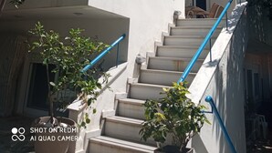Un edificio a più piani con una scala, balconi e antenne paraboliche.
