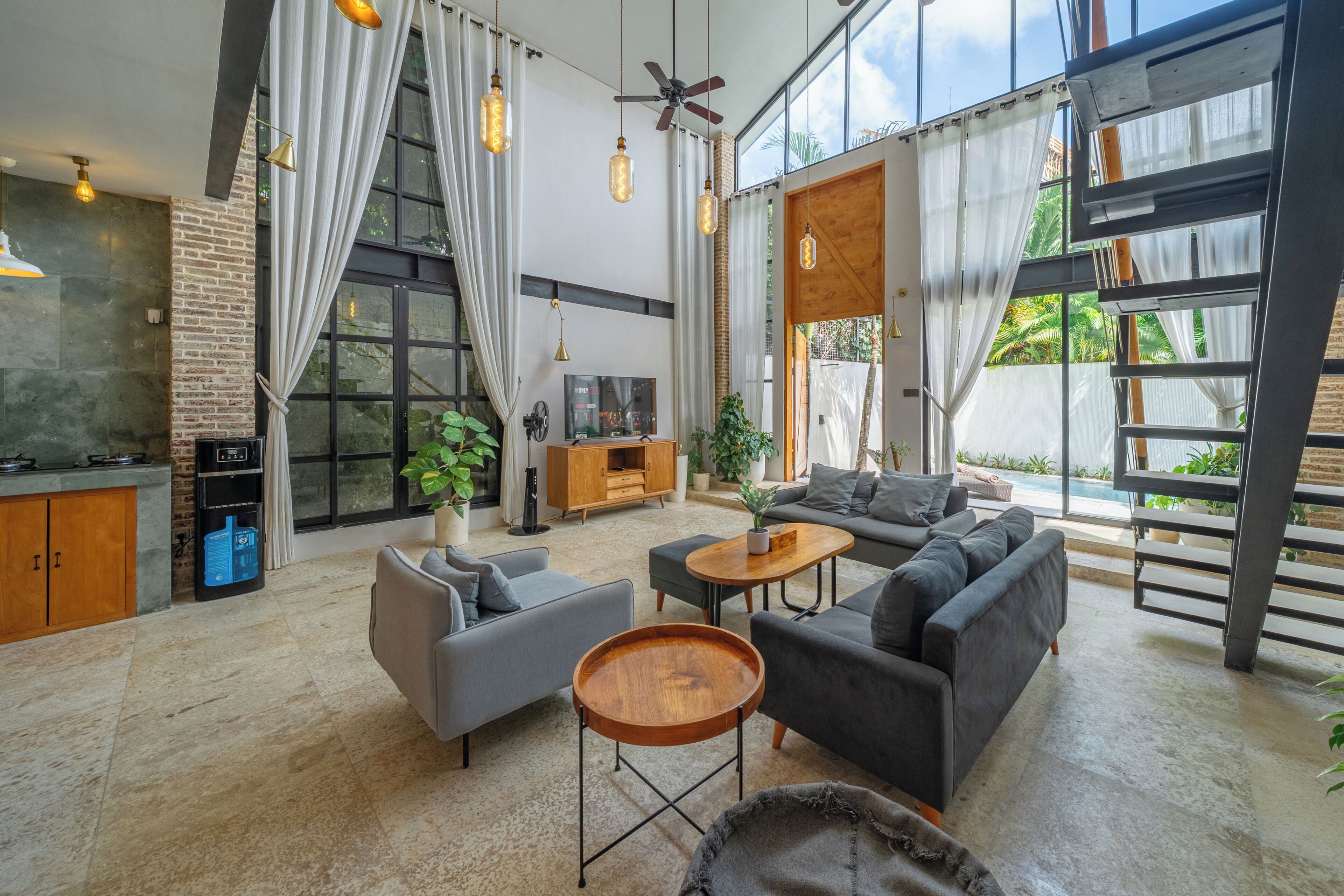 Een ruime woonkamer met een moderne zithoek, een salontafel en een televisie op een houten kast.