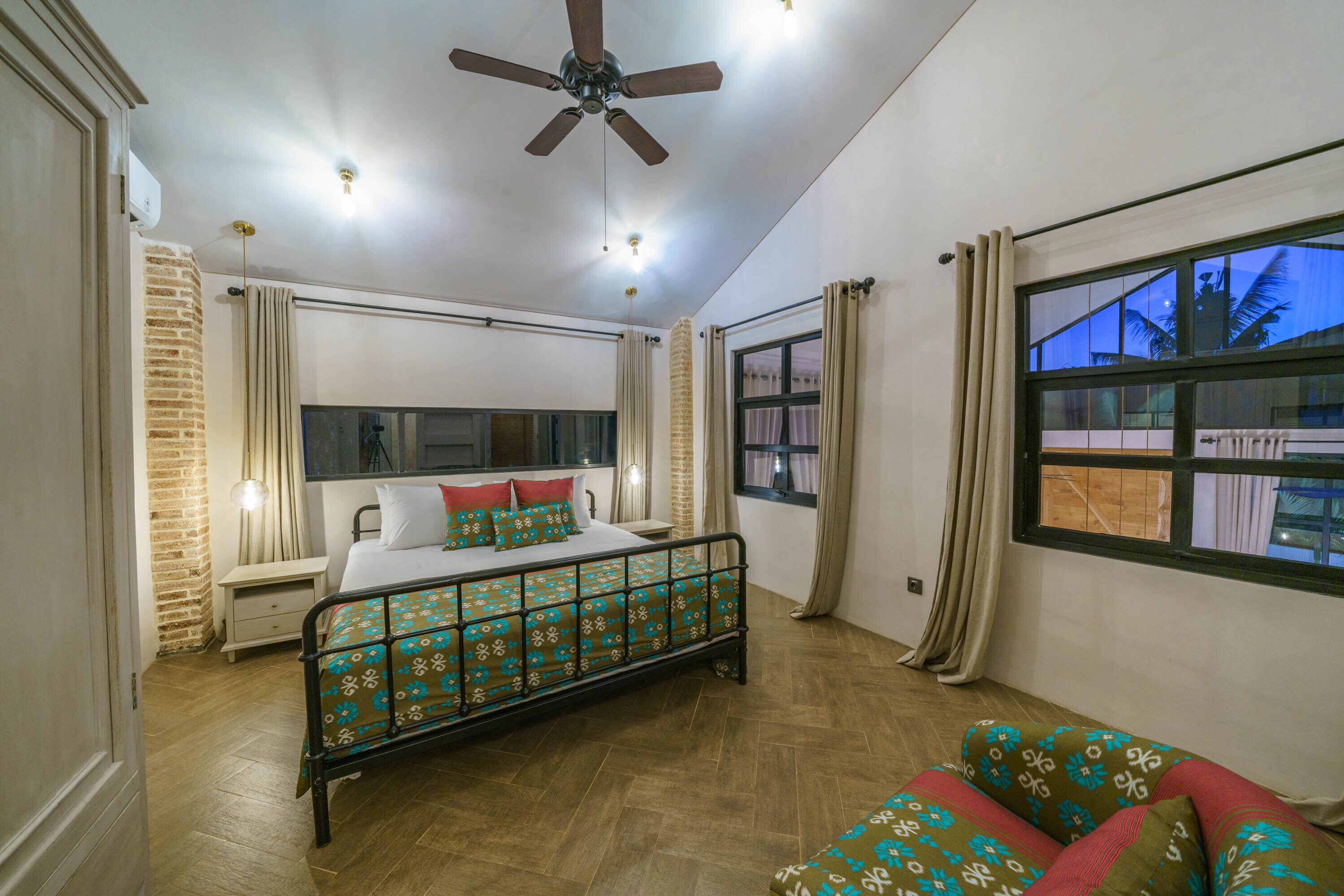 A bedroom with a bed, a nightstand, a window, and a ceiling fan.
