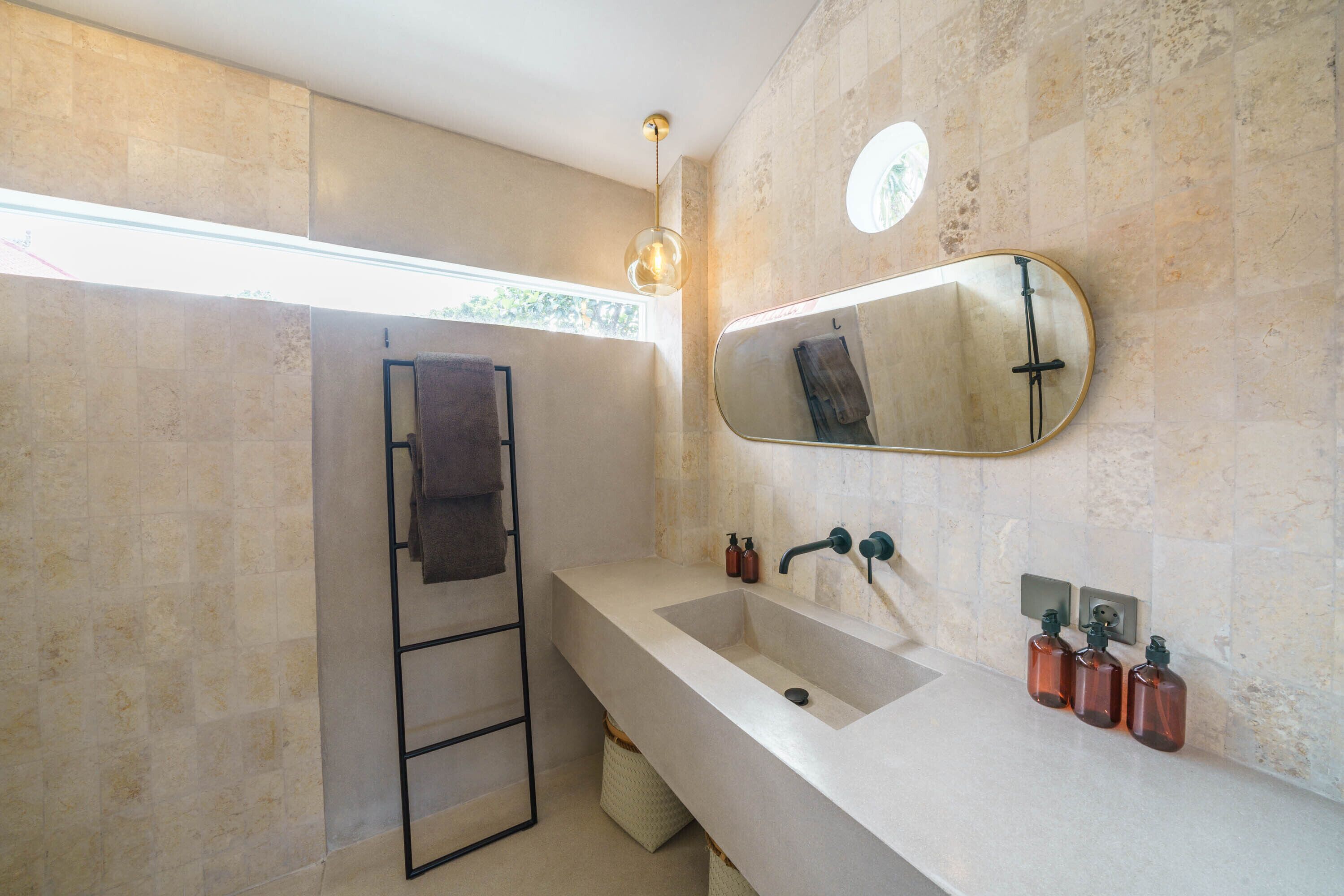Une salle de bain avec un grand miroir, deux lavabos et un porte-serviettes.