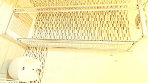 Un baño con piso de baldosas, un lavamanos blanco y una zona de ducha con techo de azulejos.