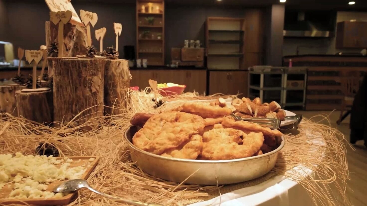 A buffet table with various fried foods and a decorative centerpiece.