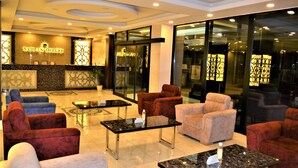 Un vestíbulo de hotel con mostrador de recepción, asientos cómodos y un diseño moderno.