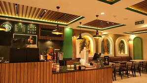 Interior de una cafetería Starbucks con paneles de madera, una barra y zona de estar.