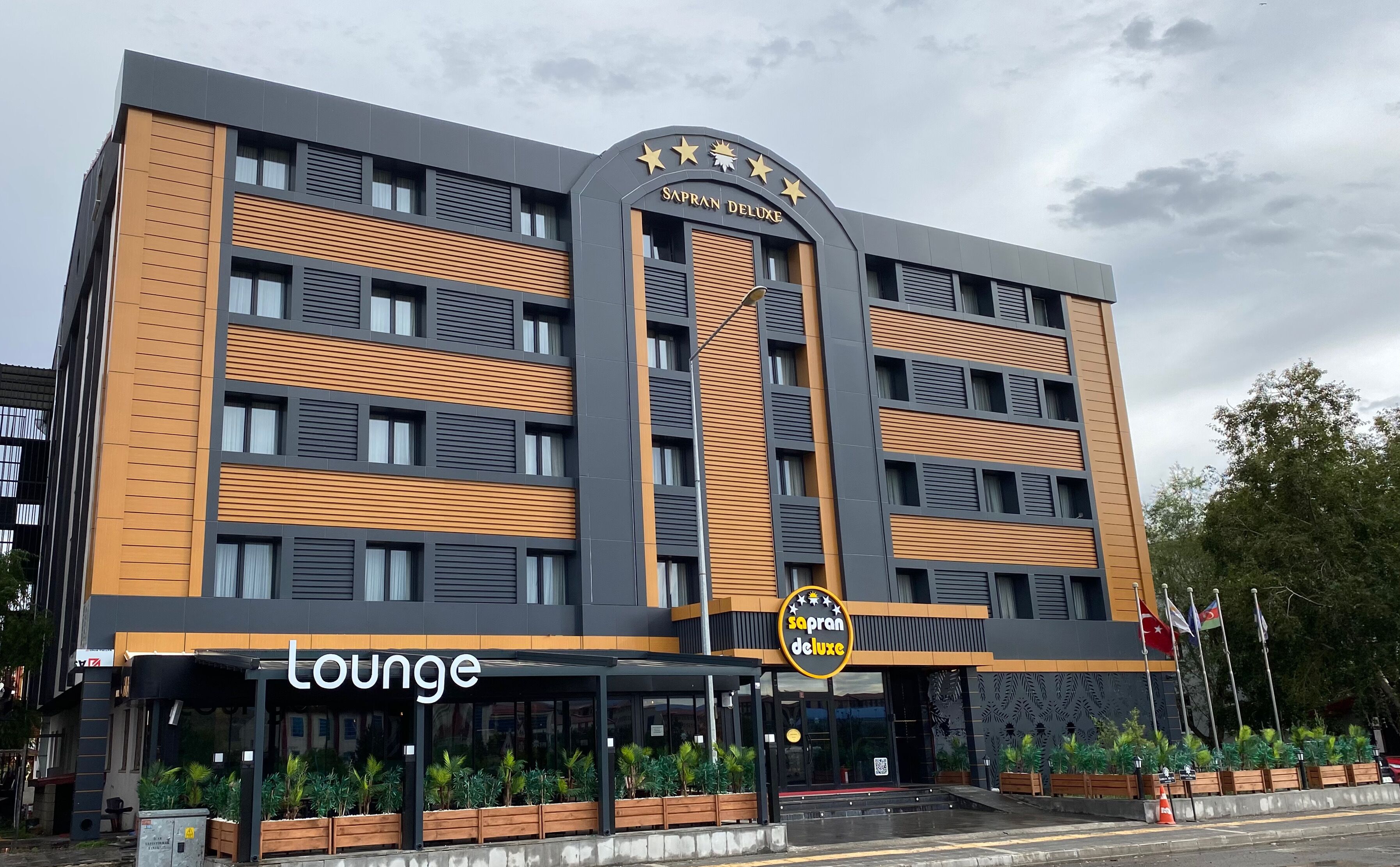 Um edifício moderno com uma placa que diz 'SAPRAN DELUXE lounge'.