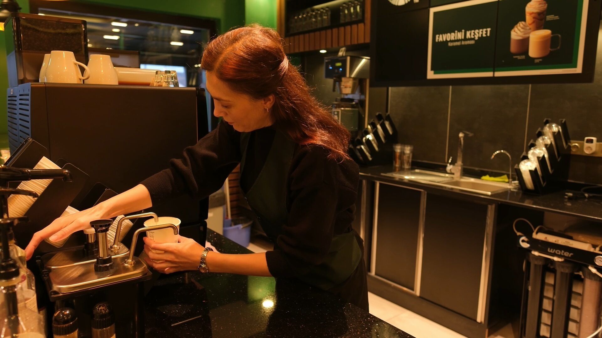 Una persona preparando café en una cocina moderna.