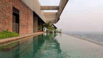 A modern building with a brick facade and a long, narrow pool extending from the structure.