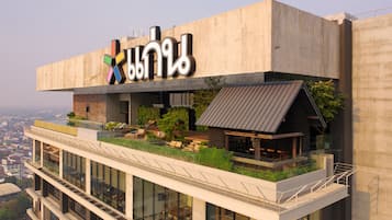 A modern building with a rooftop garden and outdoor seating area.