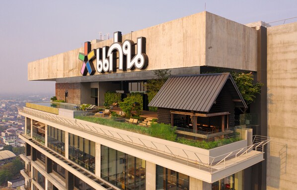 Un edificio moderno con jardín en la azotea y zona de estar al aire libre.
