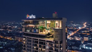 Un edificio de gran altura con bar y restaurante en la azotea, con vistas panorámicas de la ciudad.