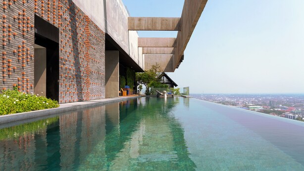 Una piscina infinita moderna con vistas despejadas al paisaje urbano de fondo.