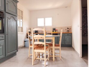 A kitchen with a dining table and chairs, a window, and a door.