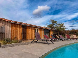 A wooden building with a tiled roof, a pool with sun loungers, and a clear sky. - Private Estate with Pool, Pond, and Lofts in Berry (Bélâbre)