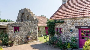 Een gebouw van steen met een rode dakbedekking en een klein torentje.