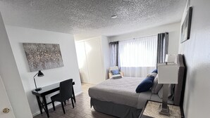 A modern bedroom with a bed, desk, chair, and a painting on the wall. - Big monthly discount. Professional travelers,relocating or just visiting. (Henderson)