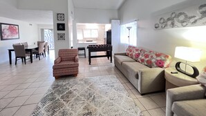 A spacious living room with a sofa, armchair, and a foosball table. - Big monthly discount. Professional travelers,relocating or just visiting. (Henderson)