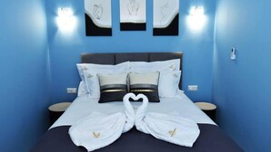 Ein Hotelzimmer mit einem Bett, Kissen und Handtüchern, die zu einem Herz geformt sind.