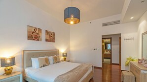 A modern bedroom with a large bed, bedside lamps, and artwork on the wall. - Splendid View 2 Bedroom Apartment in the Palm Jumeirah (Dubai)