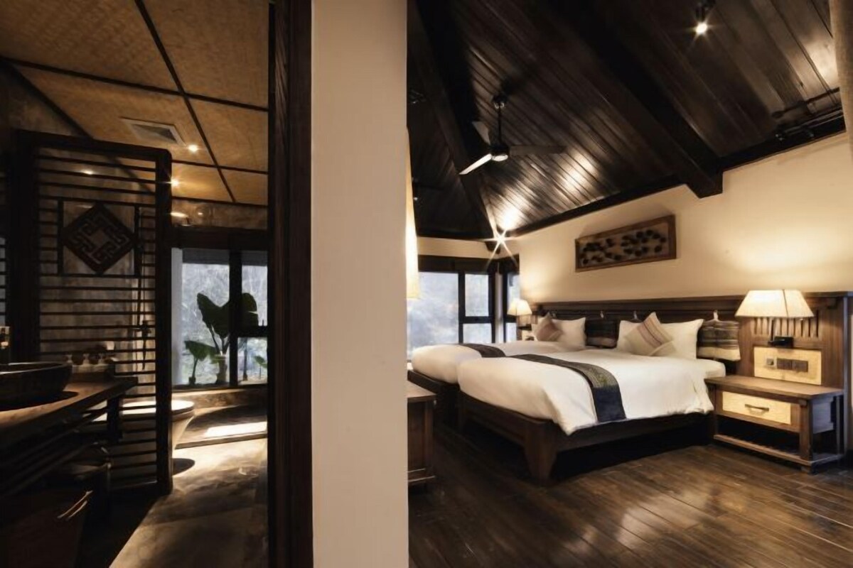 Une chambre avec un grand lit, des tables de chevet et une vue sur l’extérieur.