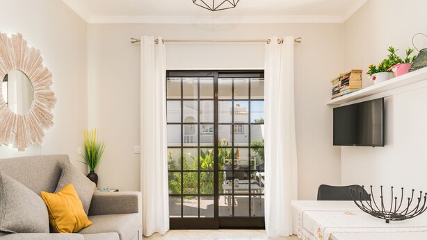 A modern living room with a sofa, a dining table, and a sliding glass door leading to a balcony. - Saule Apartment, Swimming Pool, Terrace !new! (Lagos)