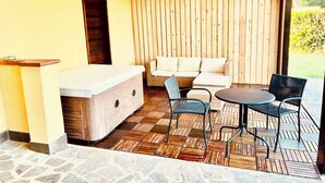 A covered patio area with a stone floor, a wooden bench, a sofa, and a table with chairs. - House I Limori with garden and parking (Gello)