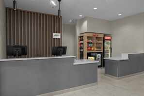 Un espace d’accueil au design moderne, comprenant un comptoir d’accueil, une enseigne fixée au mur et un distributeur automatique portant l’inscription « PINGCH ».