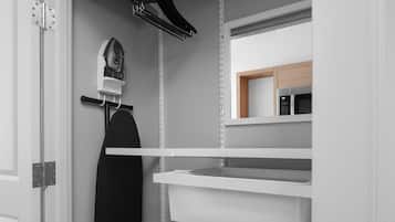 Una cocina moderna con armarios blancos, un microondas y un perchero.