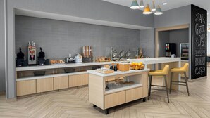 Una cocina moderna con una isla central, taburetes de bar y un cartel de desayuno.