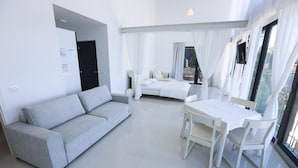 A modern, minimalist living room with a sofa, a dining table, and a bed. - Villa Molet (Koper)
