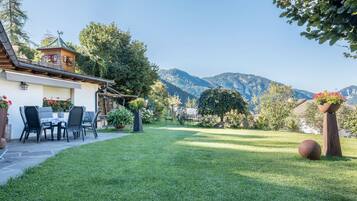 Ein Haus mit Terrasse, Essbereich und Bergblick.