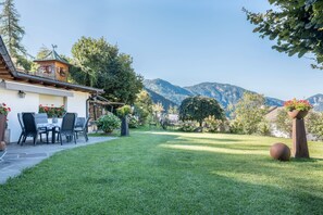 A house with a patio, a dining area, and a view of mountains. - 'Lotschenhof Apartment Margerite' with Mountain View, Garden & Wi-Fi (Trodena)