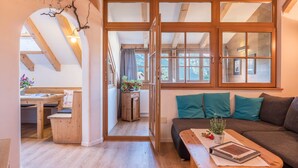 Une pièce chaleureuse avec un banc en bois, un canapé et une table agrémentée d’une plante.