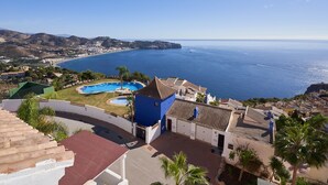 Ein Küsteneigentum mit Swimmingpool, Meerblick und einer Bergkulisse.