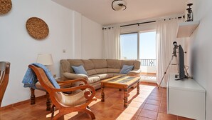 Ein Wohnzimmer mit einer Couch, einem Holzschaukelstuhl und einem Couchtisch.