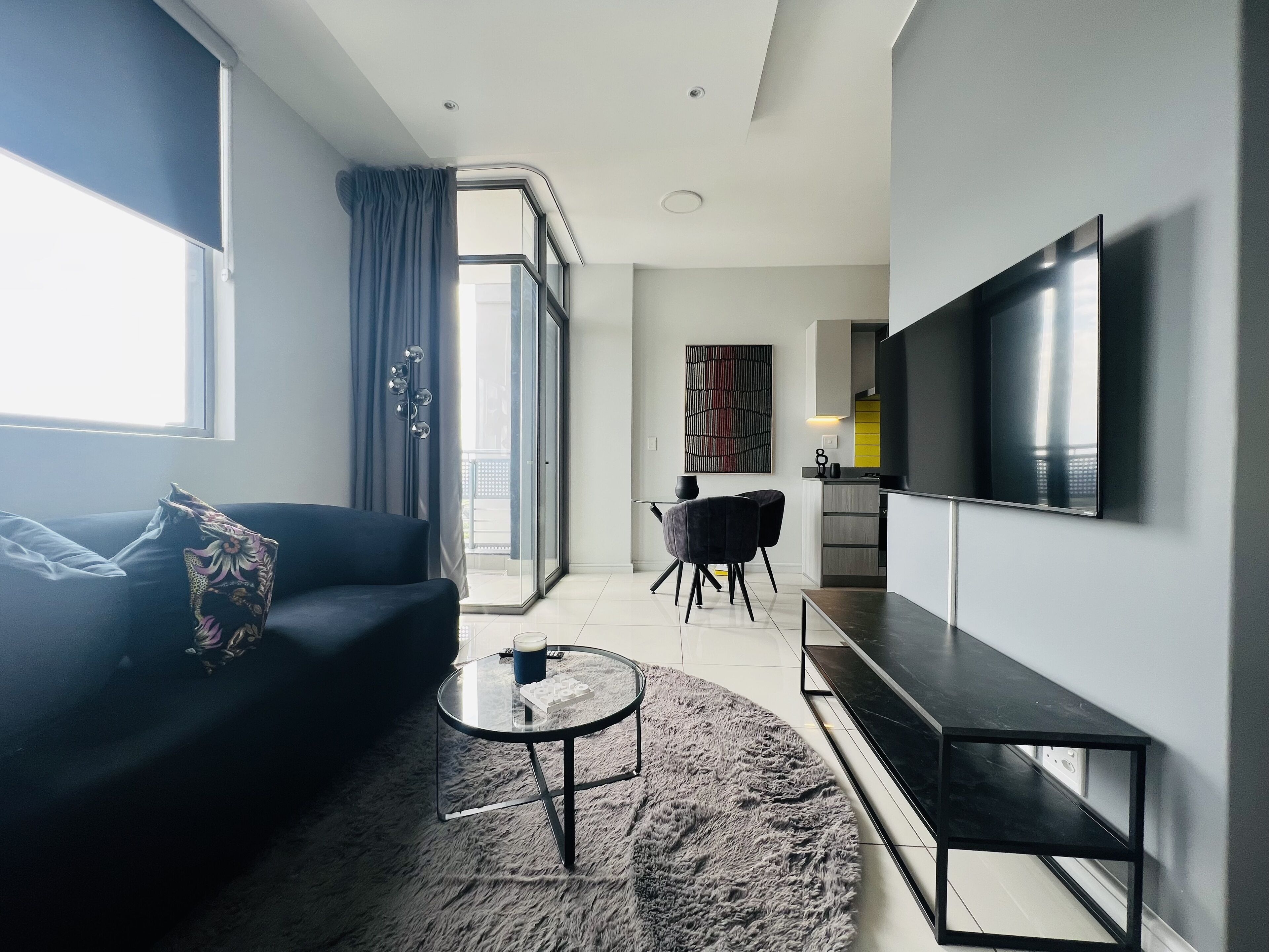 Un salon moderne avec un canapé, une table basse et un téléviseur.