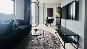 Una sala de estar moderna con un sofá, una mesa de centro y un televisor.